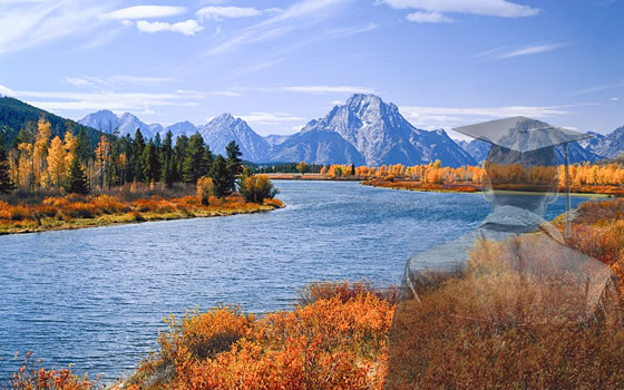 A graduate stands before the Idaho mountains